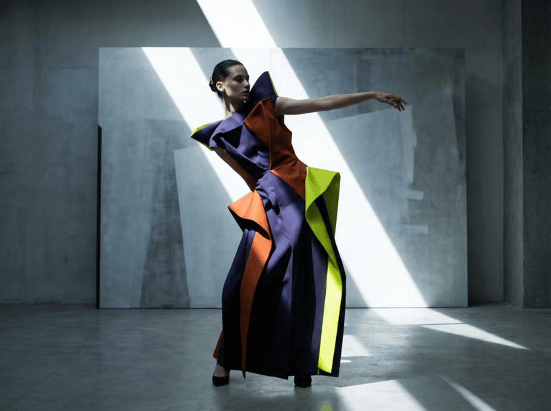AI-generated avant-garde outfit with sculptural dress and bold colors in studio.